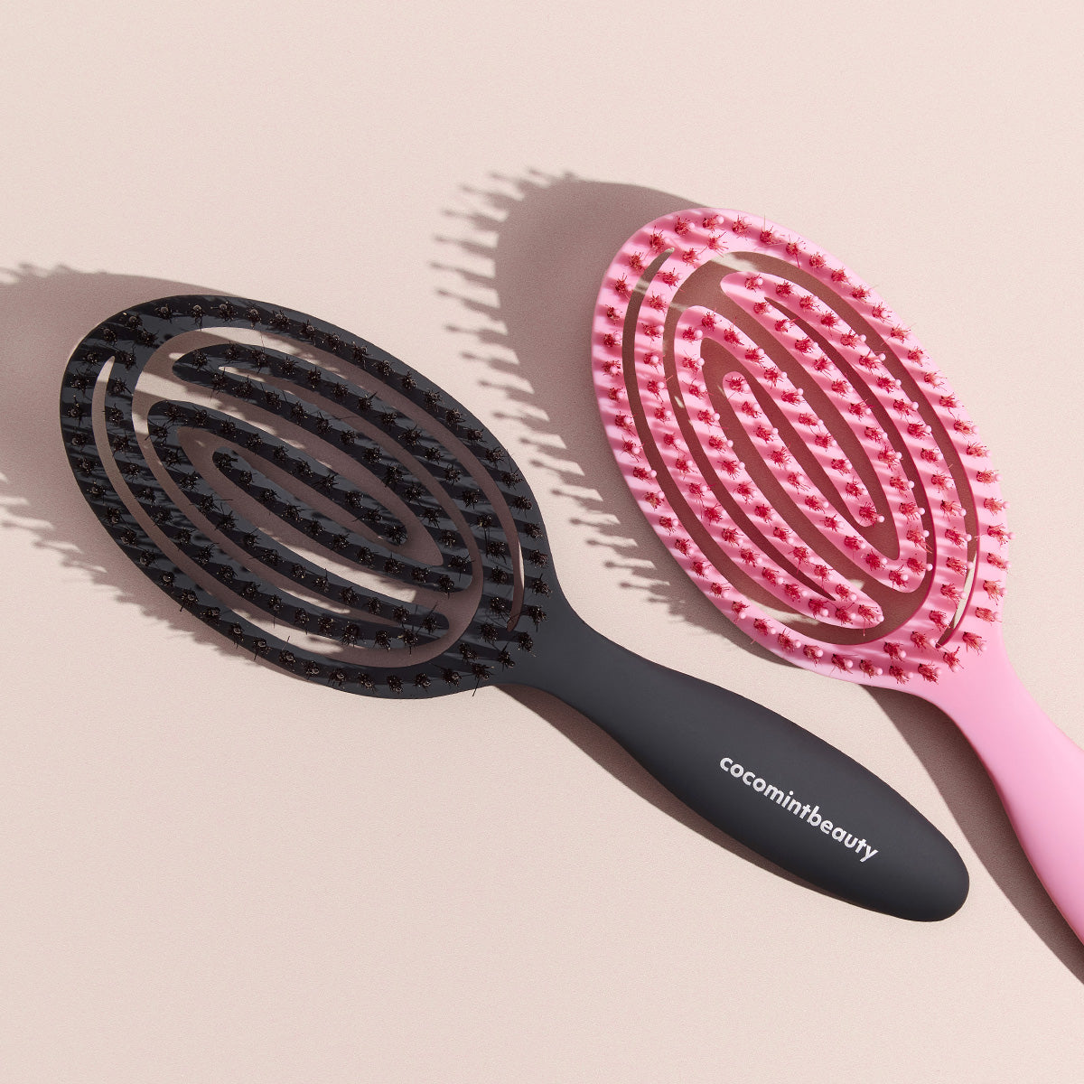 Black and pink Cocomint Beauty boar's hair bristle brushes displayed as a duo