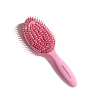 Pink hairbrush with bristle head on a white background