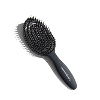 Black hairbrush with bristle head on a white background