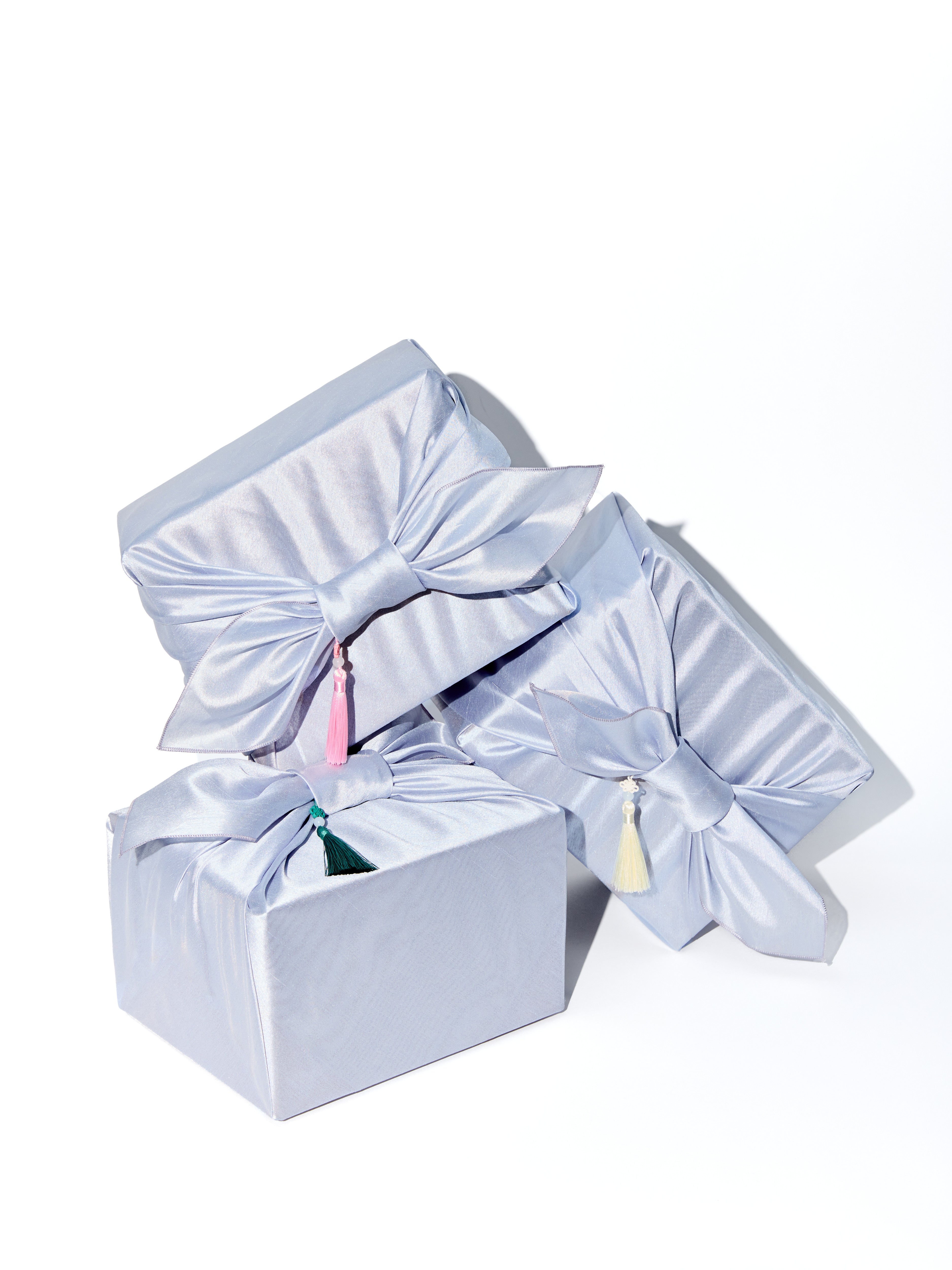 Set of three light blue gift boxes with ribbons on a white background