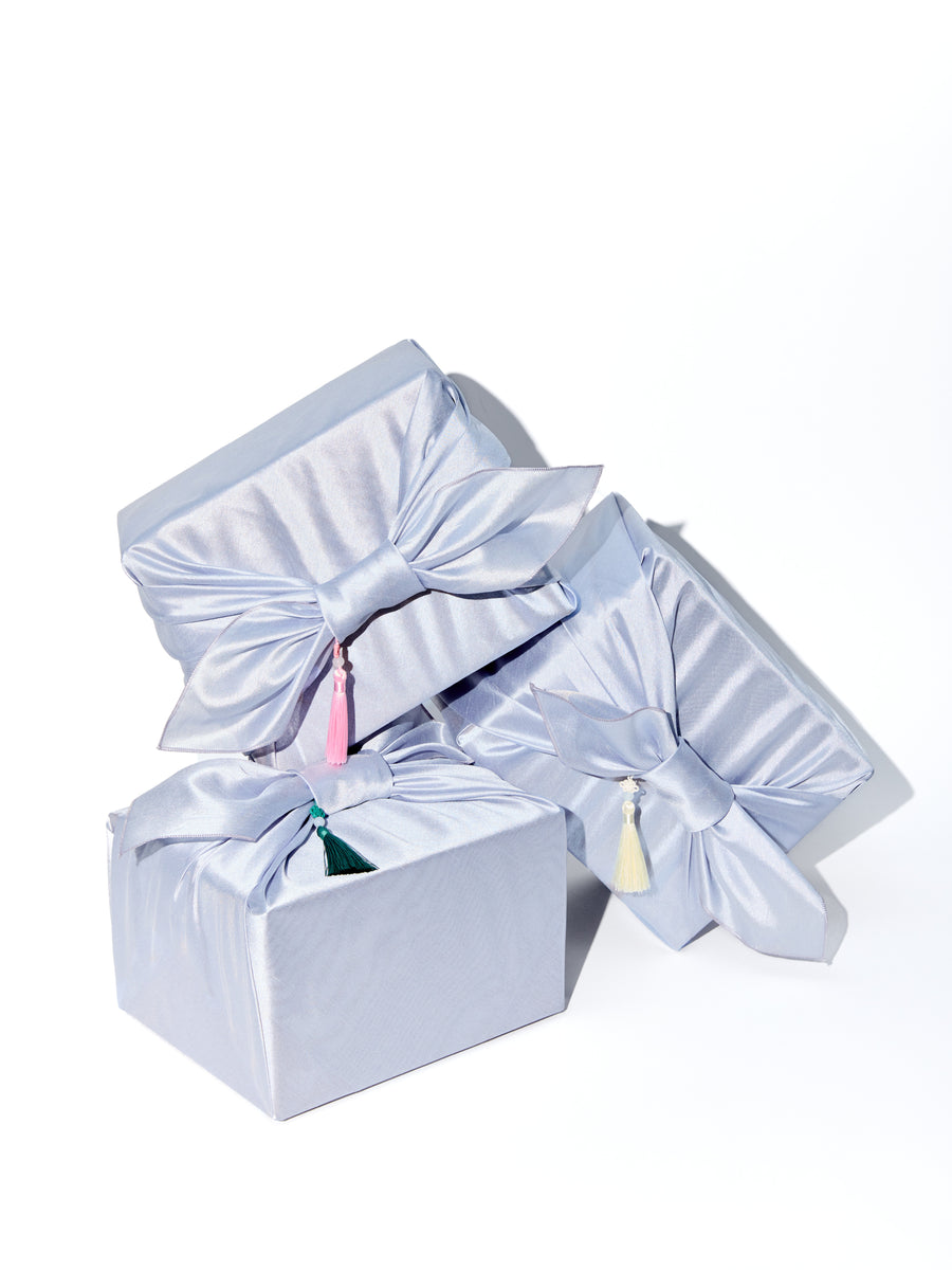 Set of three light blue gift boxes with ribbons on a white background
