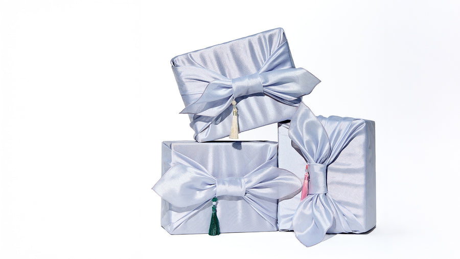 Set of three white gift boxes with decorative bows on a white background