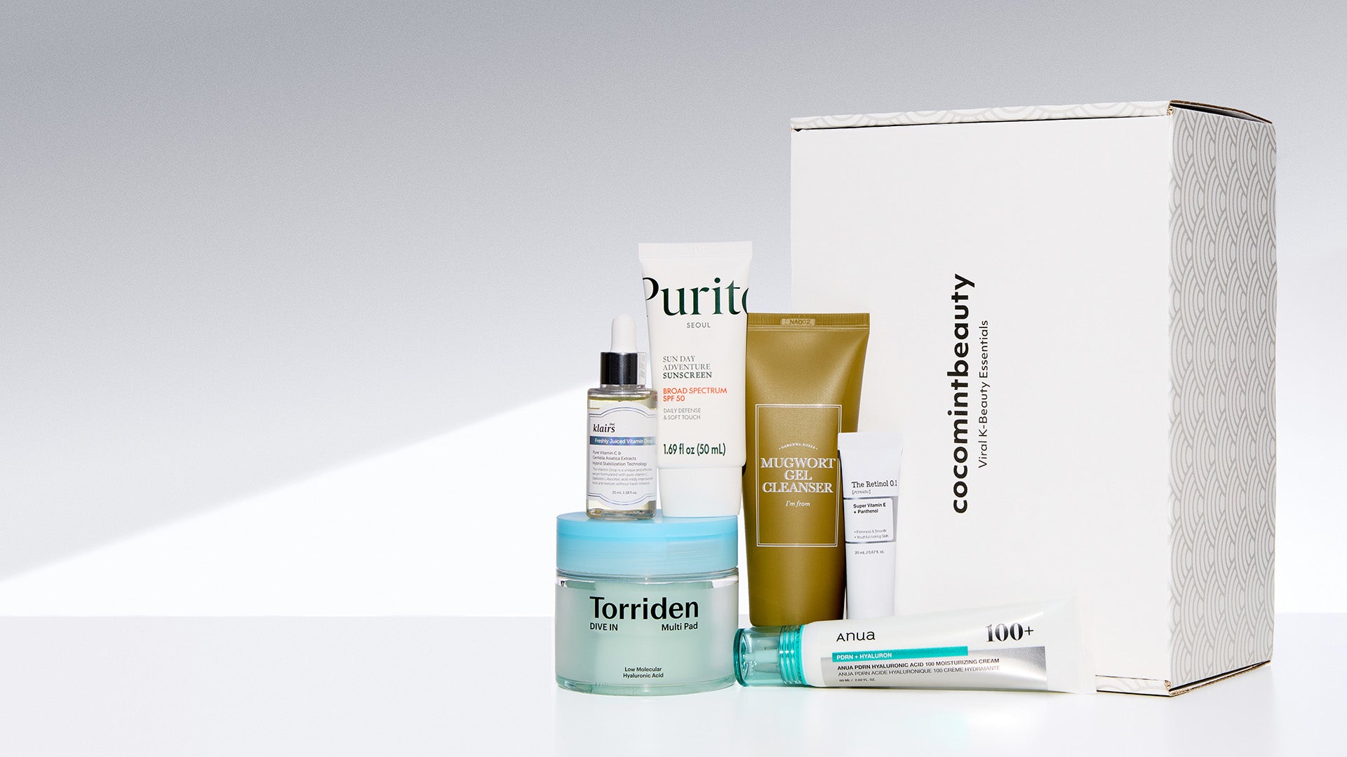 Collection of skincare products and packaging on a light gray background