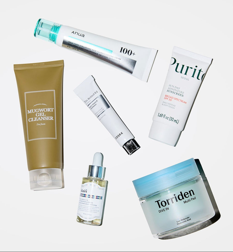 Collection of skincare products including a tube, cream, gel cleanser, and jar on a white background.