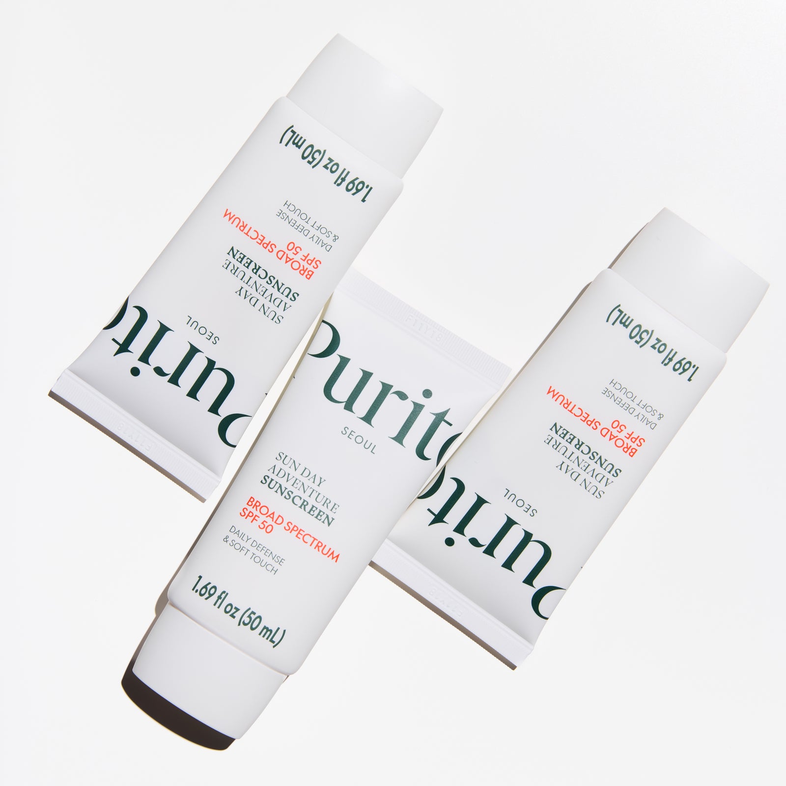 Three tubes of Puritan's Pride sunscreen on a white background