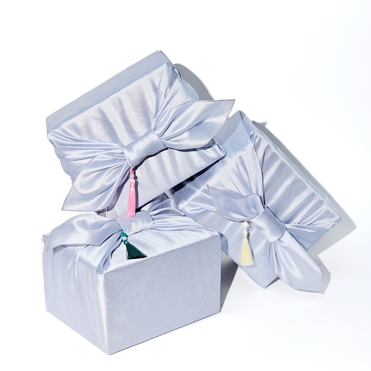 Three white gift boxes with ribbons on a white background