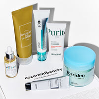 Viral K-beauty essentials box from Cocomint Beauty featuring a full Korean skincare starter kit for glass skin. Includes I'm From Mugwort Cleanser, Anua PDRN Cream, Torriden Dive-In Multi Pads, Purito Sunscreen, Klairs Vitamin Drop, and COSRX Retinol.